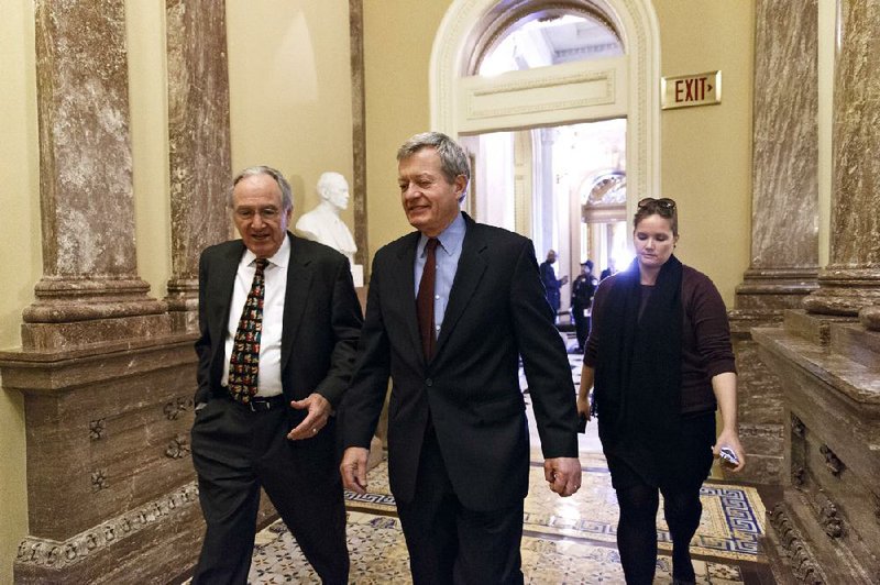 Senate Finance Committee Chairman Max Baucus, D-Mont., center, walks with Sen. Tom Harkin, D-Iowa, left, to a Democratic Caucus lunch at the Capitol in Washington, Thursday, Dec. 19, 2013. Baucus, who announced earlier this year that he would not seek re-election, is President Barack Obama’s choice to be the next U.S. ambassador to China. (AP Photo/J. Scott Applewhite)