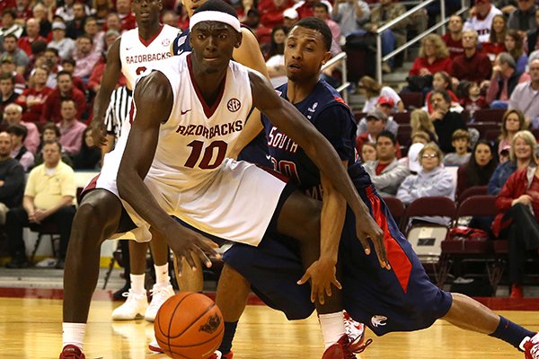 Arkansas' Bobby Portis dribbles before a lay up as South Alabama's Aakim Saintil defends during their game at Verizon Arena December 21, 2013. 