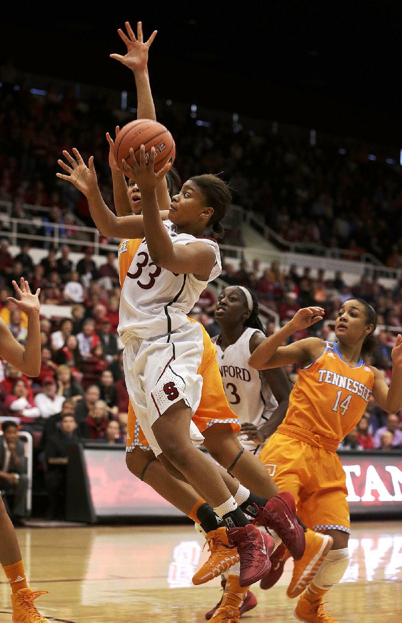 Stanford guard Amber Orrange (33) drives to the basket against Tennessee center Isabelle Harrison (20) as guard Andraya Carter (14) looks on during the second half of an NCAA women's college basketball game, Saturday, Dec. 21, 2013, in Stanford, Calif. Stanford won 76-70. (AP Photo/Tony Avelar)