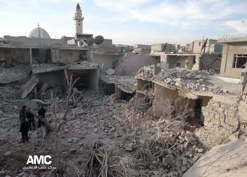 This citizen journalism image provided by Aleppo Media Center, AMC, which has been authenticated based on its contents and other AP reporting, Syrian citizens stand on rubble of houses that were destroyed due to Syrian forces airstrikes in Aleppo, Syria, Wednesday, Dec. 18, 2013. Syrian government aircraft dumped barrels packed with explosives on at least four opposition-held neighborhoods of Aleppo on Wednesday, the fourth day of stepped-up airstrikes on the contested northern city, activists said. (AP Photo/Aleppo Media Center AMC)