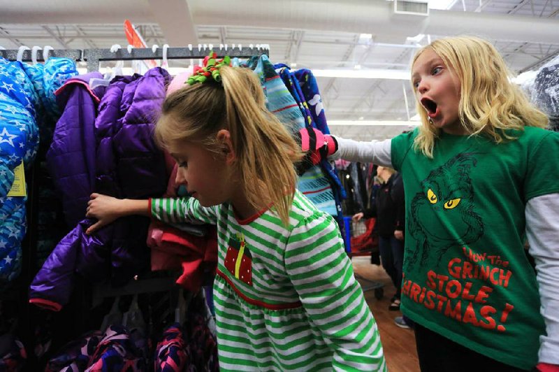 Arkansas Democrat-Gazette/RICK MCFARLAND --12/10/13-- Maci Jordan (left) and Chloe King, both second gtraders at Woodrow Cummins Elementary in Conway, look for a coat to fit a 5-year old girl during a shopping spree Tuesday at WalMart on Dave Ward Dr. in Conway. Their class raised $1066 for 5 Christmas Angels progtram through the Salvation Army. 