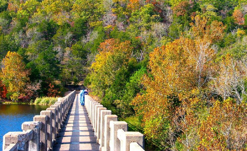 Autumn hikers cross the dam at Lake Leatherwood in Eureka Springs. The 3.5-mile
trail around the lake takes visitors to a variety of landscapes.
Photo by Michael Storey