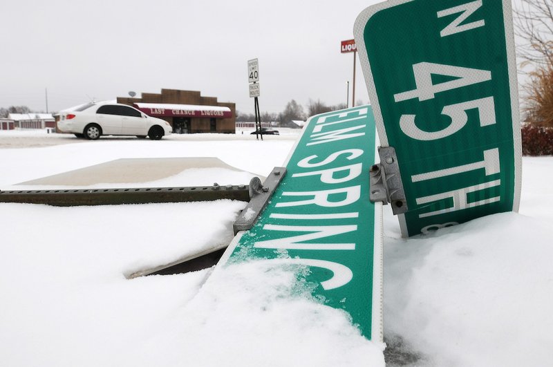 A motorist drives east on Elm Springs Road on Sunday, Dec. 8, 2013, in Springdale. Several stop signs, including the one at North 45th Street and Elm Springs Road, were damaged after a snow and ice storm hit northwest Arkansas.
