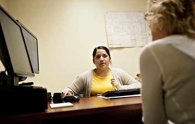 Samantha Guzman, an Affordable Care Act navigator with the Bureau and Putnam County Health Department, center, assists Jackie Karns as she shops for health insurance at the Bureau County Health Department offices in Princeton, Illinois, U.S., on Wednesday, Dec. 18, 2013. Todays deadline for Americans to sign up for Obamacare health coverage effective Jan. 1 was extended until midnight tomorrow as heavy traffic to the online enrollment system caused a queuing system to be activated Photographer: Daniel Acker/Bloomberg *** Local Caption *** Samantha Guzman; Jackie Karns