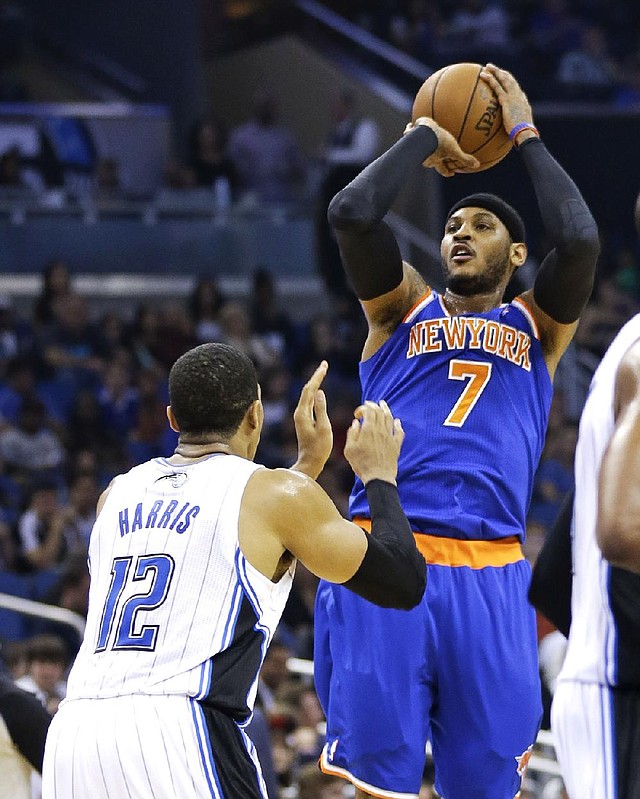 New York Knicks' Carmelo Anthony (7) shoots over Orlando Magic's Tobias Harris (12) in the first half of an NBA basketball game in Orlando, Fla., Monday, Dec. 23, 2013. (AP Photo/John Raoux)