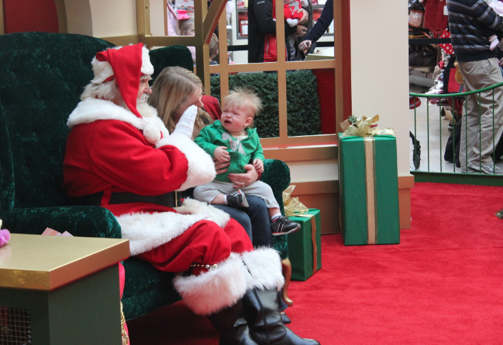 Dianne Kennedy tries to calm her 1-year-old son, Peter, for a photo with Santa before commencing last-minute Christmas shopping Tuesday at Park Plaza Mall.