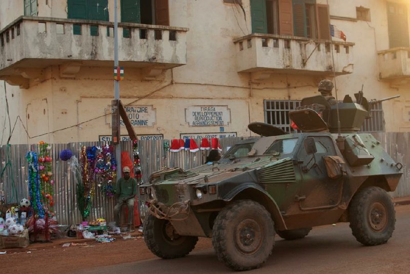A French armored personnel carrier drives past a small Christmas market in downtown Bangui, Central African Republic, on Tuesday. 