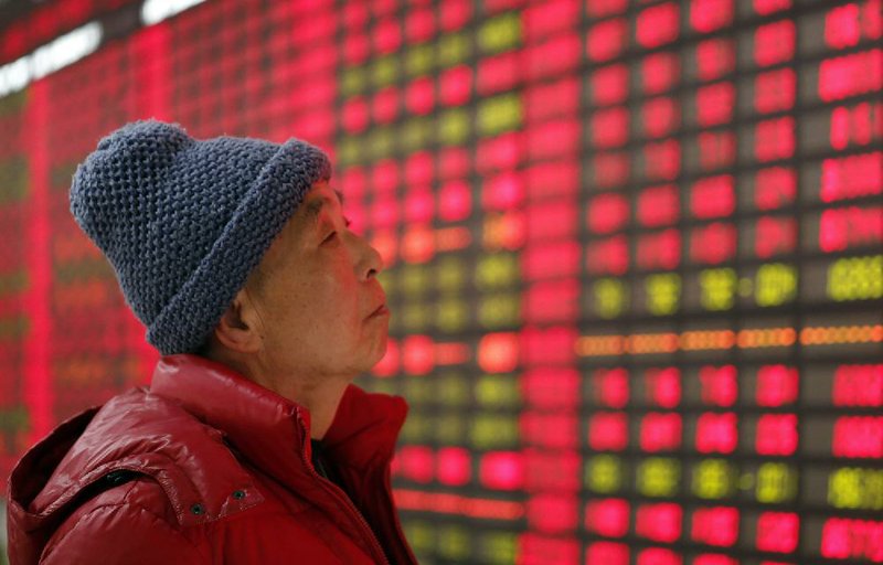 An investor looks at a stock-price monitor at a private securities company Tuesday in Shanghai. 