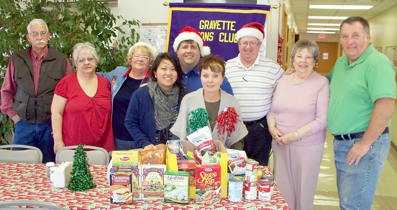 Submitted Photo Members of the Gravette Lions Club donated food items to the Harvest Baptist Church food pantry, which serves the Gravette community. Pictured are Lloyd Ashlock, Melissa Williams, Janene Ashlock, MaiKia Vang Thao, Byron Warren, CJ Foxx, Ron Theis, Mary Kay Kelly and Ken Foxx.