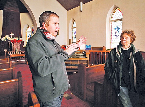 STAFF PHOTO DAVID GOTTSCHALK 
Bobby R. Braly, left, Historic Cane Hill executive director, stands Tuesday with T.A. Sampson, a church elder and Cane Hill resident, inside the Cane Hill Presbyterian Church as he describes the church’s history and the history of surrounding structures in Cane Hill. The Presbyterian Church was built in 1891.