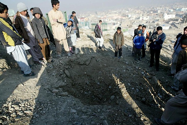 A crowd gathers Wednesday near a crater blasted by a missile attack that targeted the U.S. Embassy in Kabul, Afghanistan. The embassy received some indirect damage, but no Americans were injured. 