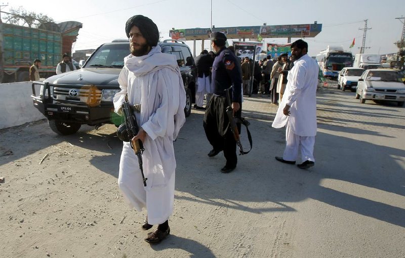 Guards of a Pakistani lawmaker are on alert during his visit to a protest camp set up to stop NATO supply trucks en route to Afghanistan due to U.S. drone attacks in tribal areas, Thursday, Dec. 26, 2013 in Peshawar, Pakistan. A suspected American drone fired two missiles at a home in a northwestern tribal region bordering Afghanistan, killing several foreign militants, Pakistani intelligence officials said Thursday. (AP Photo/Mohammad Sajjad)