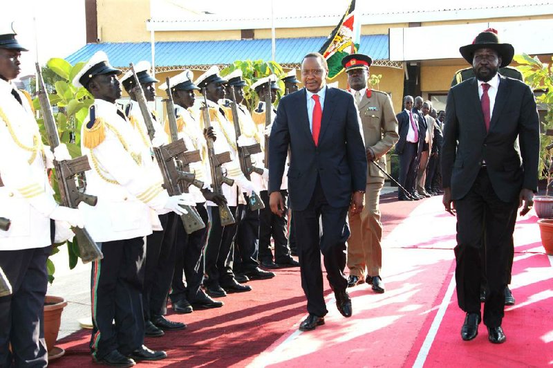 In this photo released by the Kenyan Presidential Press Service, President Uhuru Kenyatta, left, and South Sudan President Silva Kiir, right, inspect a guard of honor when the Kenyan President arrived in Juba for peace talks, South Sudan. Thursday, Dec. 26, 2013. The leaders of Kenya and Ethiopia arrived in South Sudan on Thursday to try and mediate between the country's president and the political rivals he accuses of attempting a coup that the government insists sparked violence threatening to destroy the world's newest country. (AP Photo/Kenyan Presidential Press Service)