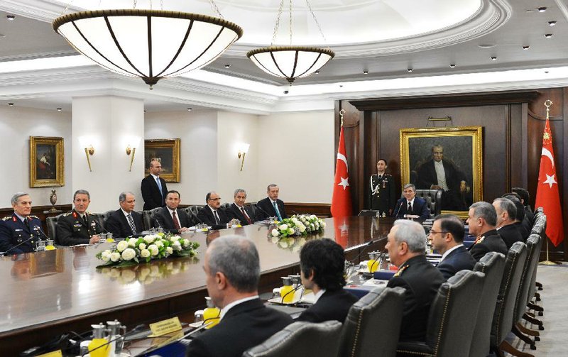 In this photo released by the Turkish Presidency Press Office, Turkish President Abdullah Gul, center, and Prime Minister Recep Tayyip Erdogan, 7th left, during a meeting of the National Security Council in Ankara, Turkey, Thursday, Dec. 26, 2013.  After a decade of dominance over Turkey's political scene, a rapidly developing corruption and bribery scandal has for the first time left Erdogan looking off balance and not in control of the political reins.(AP Photo/Mehmet Demirci, Turkish Presidency Press Office, HO) 