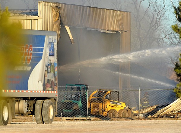 Firefighters from Lowell, Bethel Heights and Springdale work on spraying down a fire at USA Metal on 721 S Lincoln St in Lowell Thursday afternoon.  Firefighters were called to the scene late Thursday afternoon to fight the blaze.
