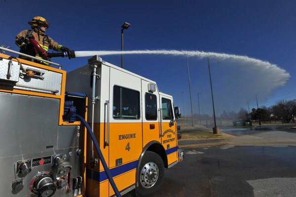 Springdale probationary firefighter Osburn Lawson works the water cannon during a training exercise Thursday afternoon at J.B. Hunt Park in Springale.  Springdale firefighters took advantage of the weather temperatures rising above freezing to allow some of their new firefighters to train on on different equipment on the fire engines.