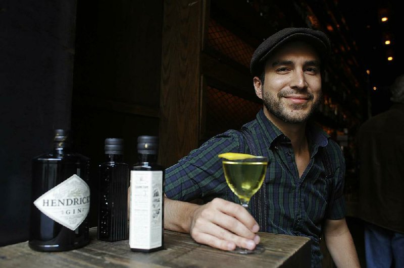 In this photo taken Wednesday, Oct. 30, 2013, bartender Dan Chavez Stahl sits with a drink he calls the Quinundrum, made with Quinetum, a new quinine cordial by Hendrick's Gin, at the Rickhouse bar in San Francisco. Quinetum is sold exclusively to a few bars around the country. (AP Photo/Eric Risberg)