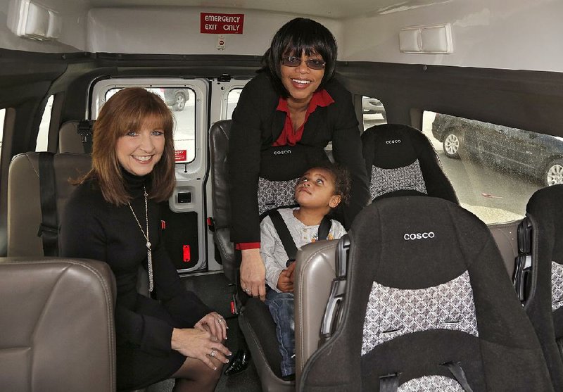 Arkansas Democrat-Gazette/JOHN SYKES JR - HIGH PROFILE VOLUNTEER - Debbie Grooms (left) started a fundraiser at Arkansas Enterprises for the Developmentally Disabled to purchase new car seats. Here she shows off the new seats with principal Mary Giles and student Brock, 3. 121913