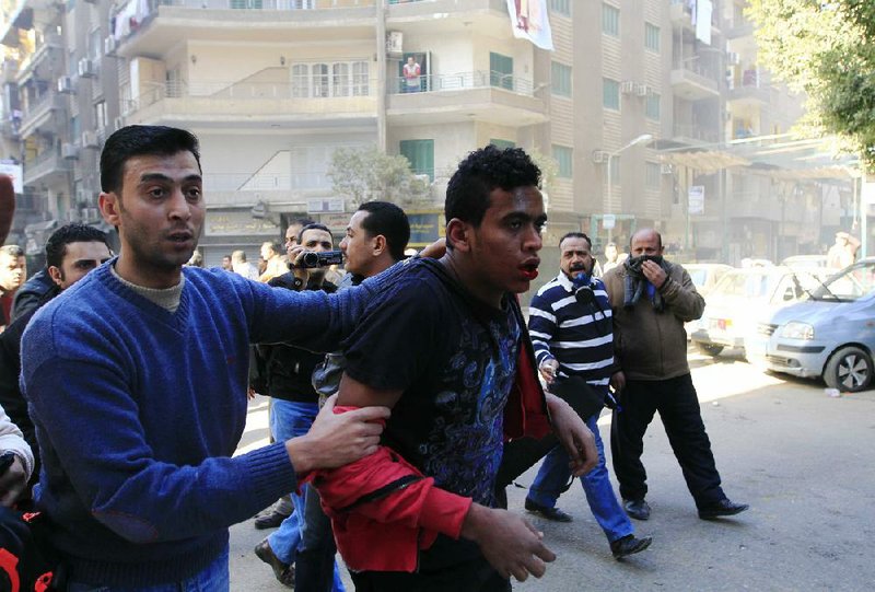 A plainclothes police officer, left, detains one of the supporters of Egypt's ousted President Mohammed Morsi following their demonstration in Cairo, Egypt, Friday, Dec. 27, 2013. Egyptian security forces fired tear gas and clashed with hundreds of Morsi supporters around the country Friday as authorities tightened security measures in the capital after Morsi's Muslim Brotherhood and its allies renewed calls for mass rallies. (AP Photo/El Shorouk newspaper, Ahmed Abd El Latif) EGYPT OUT