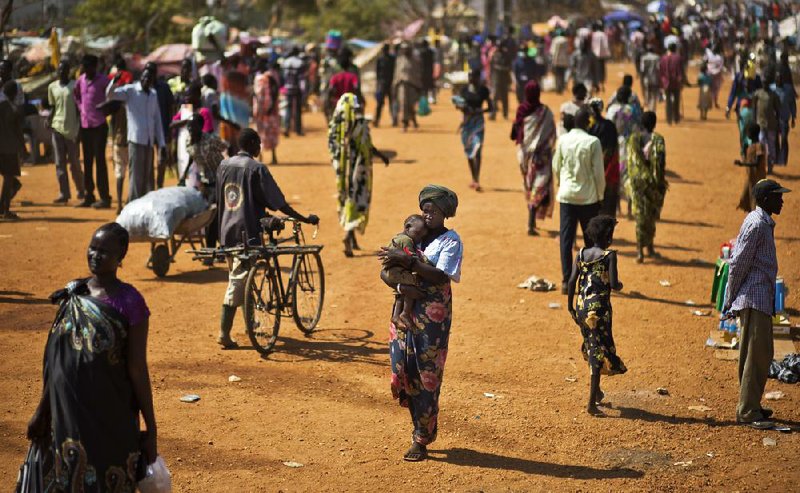 Displaced people walk inside a United Nations compound which has become home to thousands of people displaced by the recent fighting, in Juba, South Sudan Friday, Dec. 27, 2013. Kenya's president Uhuru Kenyatta on Friday urged South Sudan's leaders to resolve their political differences peacefully and to stop the violence that has displaced more than 120,000 people in the world's newest country, citing the example of the late Nelson Mandela and saying there is "a very small window of opportunity to secure peace" in the country where fighting since Dec. 15 has raised fears of full-blown civil war. (AP Photo/Ben Curtis)