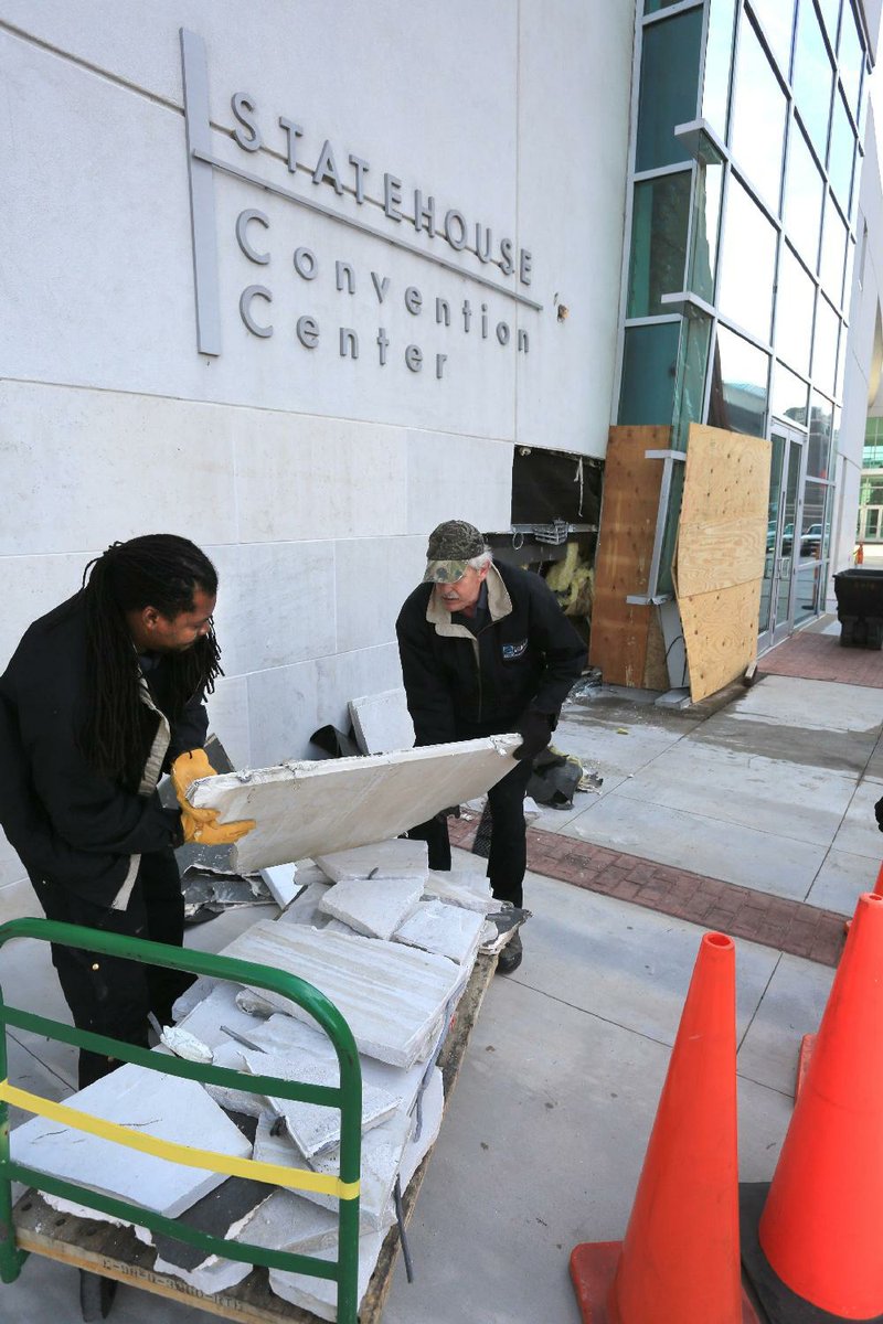 Arkansas Democrat-Gazette/RICK MCFARLAND --12/27/13--  Cortez Jackson (left) and William Moore load pieces Friday of the stone wall that was damaged when a vehicle struck the Statehouse Convention Center the previous night in Little Rock. Some of the glass panes were also broken. The driver of the vehicle was not seriously injured.