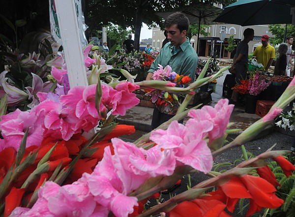 Peter Sparklin of Dripping Springs Garden in Huntsville puts together a flower arrangement for a customer Saturday afternoon at the Fayetteville Farmers Market on the Fayetteville square.  The Farmers Market will have a Back to School party on the square Tuesday August 13th at 9am.