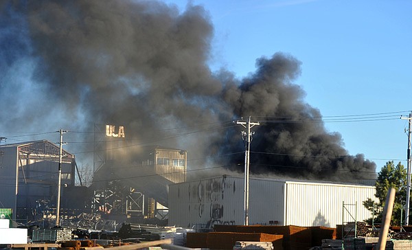 Smoke rises up from a fire at USA Metal on 721 S Lincoln St in Lowell Thursday afternoon. Firefighters from Lowell, Behtel Heights, and Springdale were called to the scene late Thursday afternoon to fight the blaze.