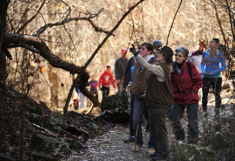 NWA Media/ANDY SHUPE - Terry Elder, a park interpreter at Devil's Den State Park, points out geological features as she leads a group of hikers Saturday, Dec. 28, 2013, on a hike along the Yellow Rock Trail. "First Day Hikes" are scheduled at Arkansas State Parks on Wednesday to help people start the new year with an experience outside.