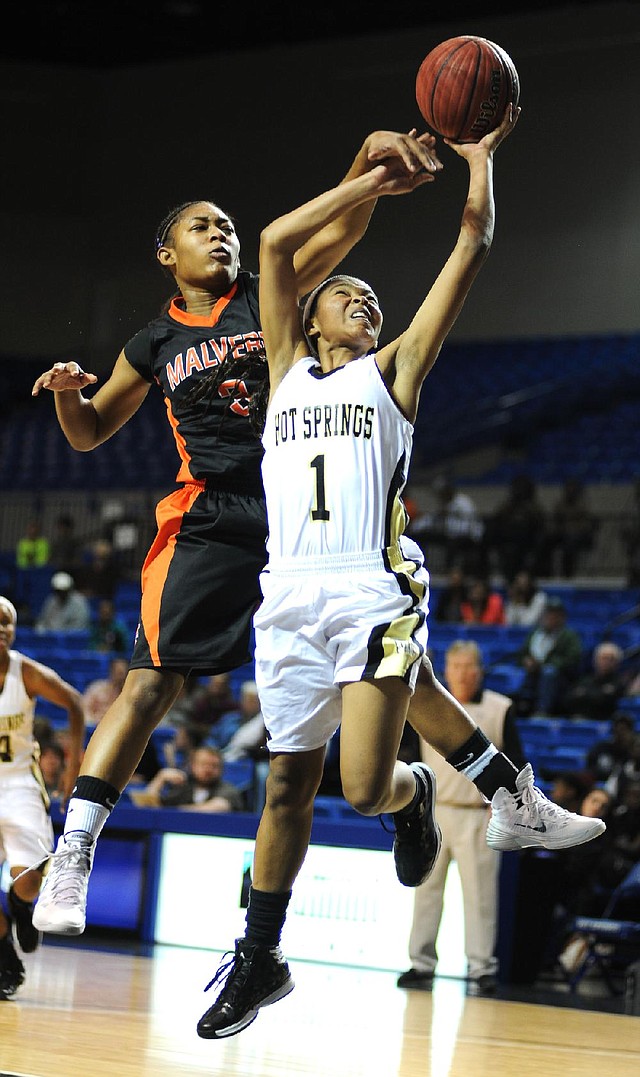 Berniezha Tidwell (1) of Hot Springs drives to the basket as Malvern’s Tiffany Murdock tries to block the shot from behind during the Lady Trojans’ 54-48 victory over the Lady Leopards on Saturday during the Spa City Shootout at Summit Arena in Hot Springs. 