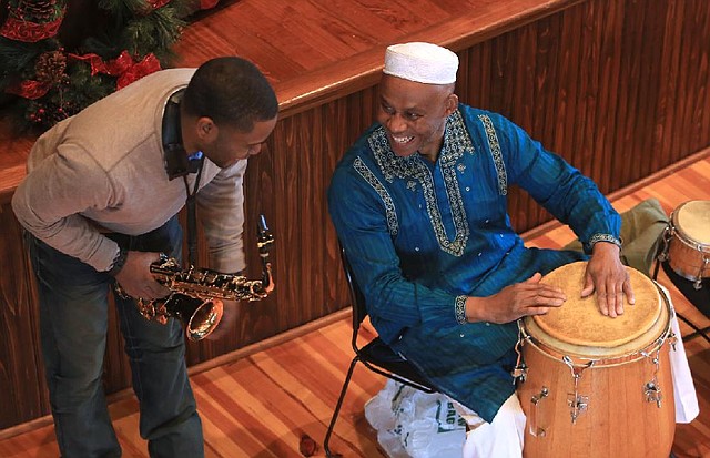 Arkansas Democrat-Gazette/RICK MCFARLAND --12/28/13--  Ricky Howard on saxaphone and Ojima Robinson, both of Little Rock, on a drums share a light moment during a celebration of Kwanzaa at the Mosaic Templars Cultural Center in Little Rock Saturday. Kwanzaa was created in 1966 as the first specifically African-American holiday and is based on the seven principles of African Heritage. It begins the day after Christmas and lasts until New Years' Day.