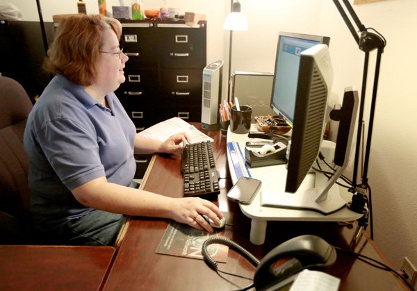 Susan Ratliff, data entry specialist, enters student data to enroll for the upcoming semester on Thursday, Dec. 19, 2013, at the NorthWest Arkansas Community College Adult Education Center inside the Center for Non-profits in Rogers.