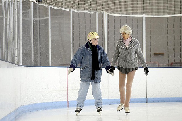 STAFF PHOTO ANTHONY REYES
Elizabeth Reagan, 91, left, skates with Marcela Taylor Thursday, Dec. 19, 2013 at the ice rink inside the Jones Center in Springdale. Reagan learned to skate as a child in St. Paul, Minn., and took it up again several years ago when the Jones Center opened up the ice rink. She skates at least once a week, wears a helmet since a past fall bloodied her head and usually skates with a partner for balance.