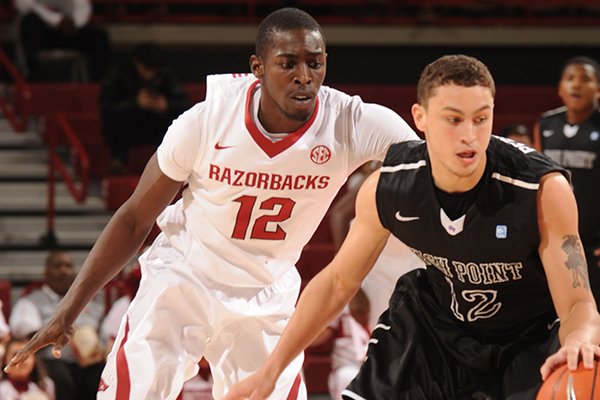 Arkansas guard Fred Gulley III, left, pressures High Point guard Jorge Perez-Laham during the first half of play Saturday, Dec. 28, 2013, in Bud Walton Arena in Fayetteville.