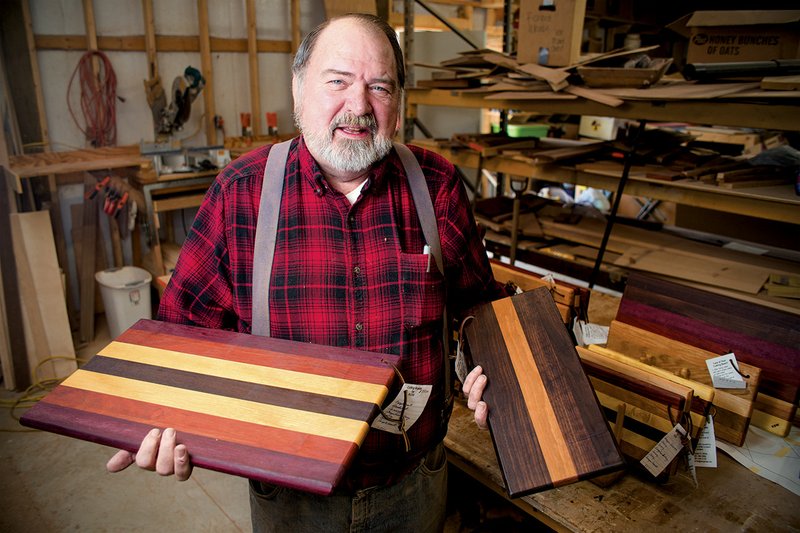 Richard White of Beebe holds samples of the cutting boards he makes from domestic and exotic hardwoods.