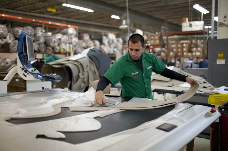Marcos Godoy of Mexico City manufactures dashboard mats for cars at a factory belonging to the Techma group in Ciudad Juarez, Mexico. The company has 14 manufacturing plants in the city. 