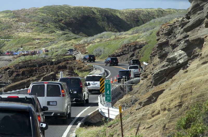 A motorcade carrying President Barack Obama and his family Tuesday heads along the southeast coast of Oahu toward the Hanauma Bay Nature Preserve Park, a popular snorkeling destination. As the president vacationed in Hawaii, his health-care law saw a late surge in enrollment, helping offset early technical foul-ups.
