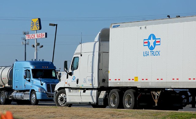 A USA Truck tractor-trailer idles in a parking area at a North Little Rock truck stop Tuesday. USA Truck’s value more than tripled last year. 