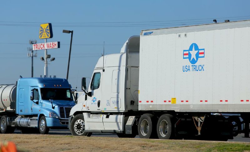 A USA Truck tractor-trailer idles in a parking area at a North Little Rock truck stop Tuesday. USA Truck’s value more than tripled last year. 