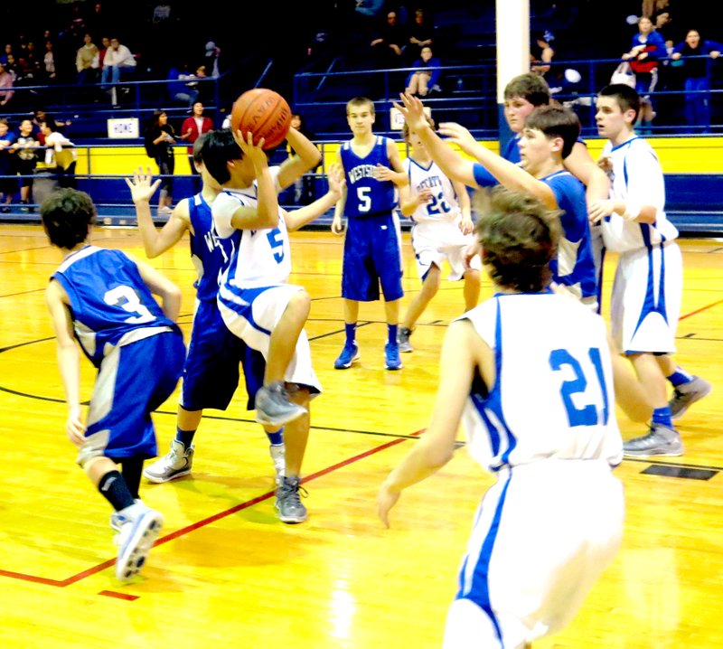 Photo by Mike Eckels Decatur Junior High guard Leng Lee (5) tries a jump shot in the midst of a circle of offensive and defensive players during the Dec. 20 matchup with Johnson County Westside at Peterson Gym in Decatur.