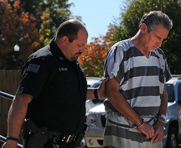 Barry Gebhart, Fayetteville High School athletic director, was escorted into court for his bond hearing Wednesday, Oct. 23, 2013, at the Benton County Courthouse Annex in Bentonville.