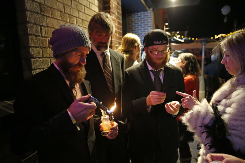 Partygoers smoke marijuana during a Prohibition-era themed New Year's Eve party celebrating the start of retail pot sales, at a bar in Denver, late Tuesday Dec. 31, 2013. Colorado is to begin marijuana retail sales on Jan. 1, a day some are calling ‘Green Wednesday.' 