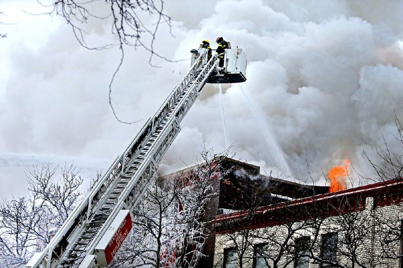 Firefighters work Wednesday to extinguish a fire that damaged several apartment units in the Cedar Riverside neighborhood in Minneapolis after an explosion was reported at 8:15 a.m. Authorities say 14 people were taken to hospitals and six were reported in critical condition.