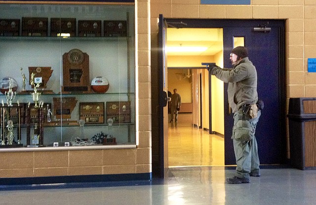 A Springdale Police officer stands at a hallway door during an Active Shooter Drill at Shiloh Christian School in Springdale.