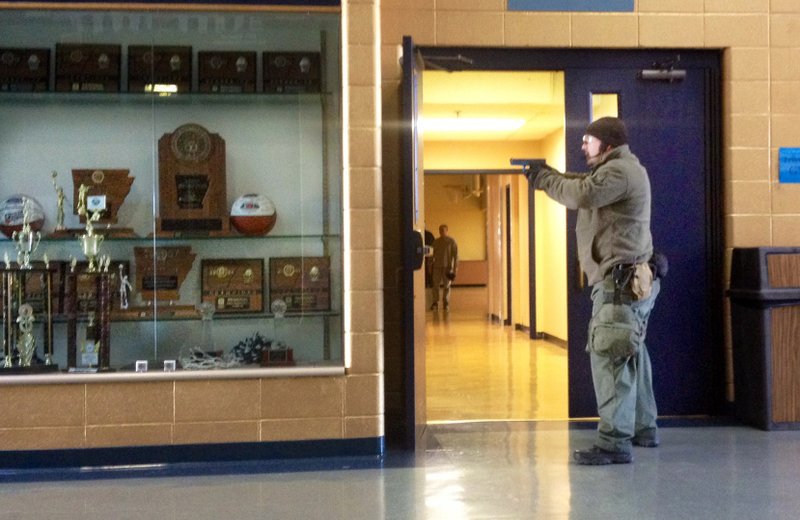 A Springdale Police officer stands at a hallway door during an Active Shooter Drill at Shiloh Christian School in Springdale.