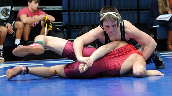 STAFF PHOTO SAMANTHA BAKER 
• @NWASAMANTHA 
Ryan Flynn, top, of Bentonville pins back the arm of Eddie Branson from Springdale on Dec. 13 during the NWA Duals tournament at War Eagle Arena in Rogers.