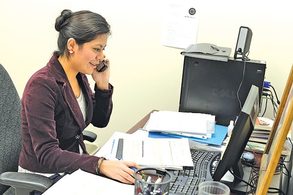 STAFF PHOTO ANTHONY REYES 
Rubicely Hernandez, GEM program coordinator for the Hispanic Women’s Organization of Arkansas, makes a few phone calls Friday, for women interested in taking classes with the organization at her office in Springdale.