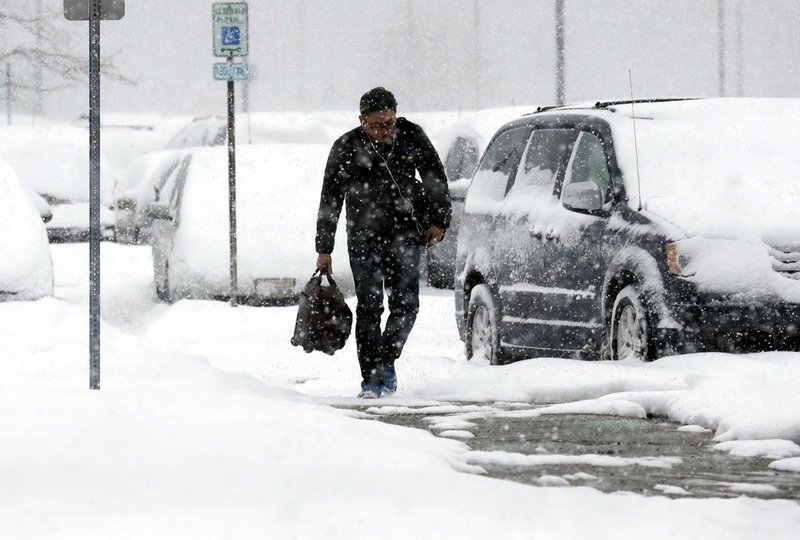 A traveler walks in the economic parking lot at O'Hare International Airport in Chicago on Thursday, Jan. 2, 2014. Another one to three inches of snow could fall across the Chicago metro area Thursday with even more falling in the southern part of the region, according to the National Weather Service. 