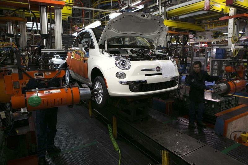 Workers put wheels on a Fiat 500 at Chrysler Group LLC's assembly plant in Toluca, Mexico, on Friday, Nov. 8, 2013. Automakers are expanding production in Mexico to capitalize on lower labor costs that bolster the profitability of vehicles sold in the U.S. market. Photographer: Susana Gonzalez/Bloomberg