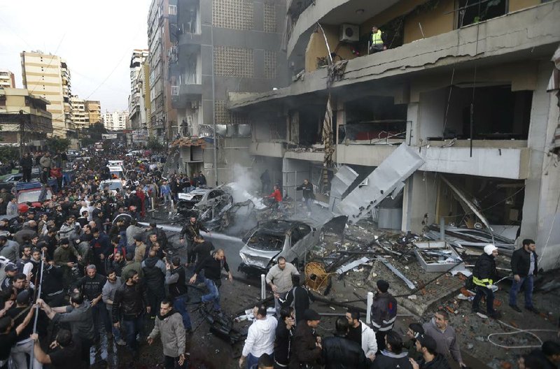 Lebanese citizens gather at the site of a car bomb explosion in a stronghold of the Shiite Hezbollah group at the southern suburb of Beirut, Lebanon, Thursday, Jan. 2, 2014. A large explosion took place during rush hour in the Haret Hreik neighborhood. (AP Photo/Hussein Malla)