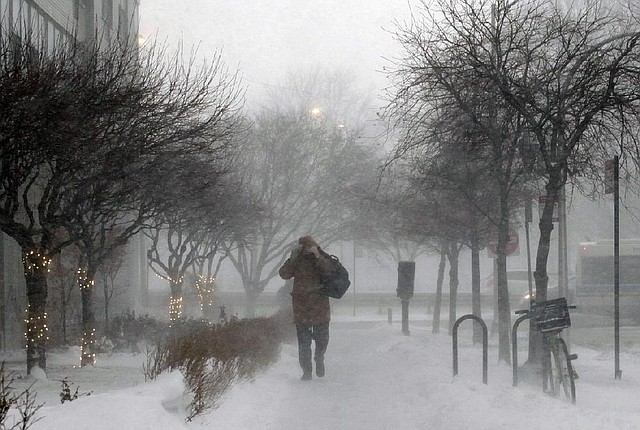 A morning commuter walks against blowing snow Thursday in Chicago. More than a foot of snow was forecast for some areas in the Northeast overnight Thursday into today, and temperatures were expected to plummet, with some areas seeing highs just above zero, according to the National Weather Service. 